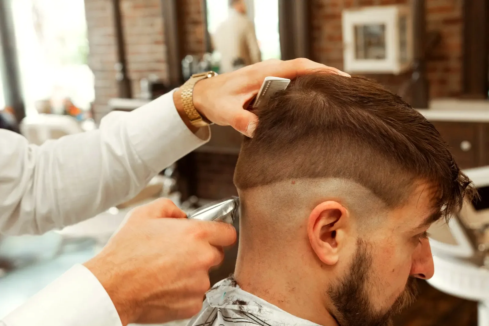Barbero haciendo un corte a un cliente sonriente