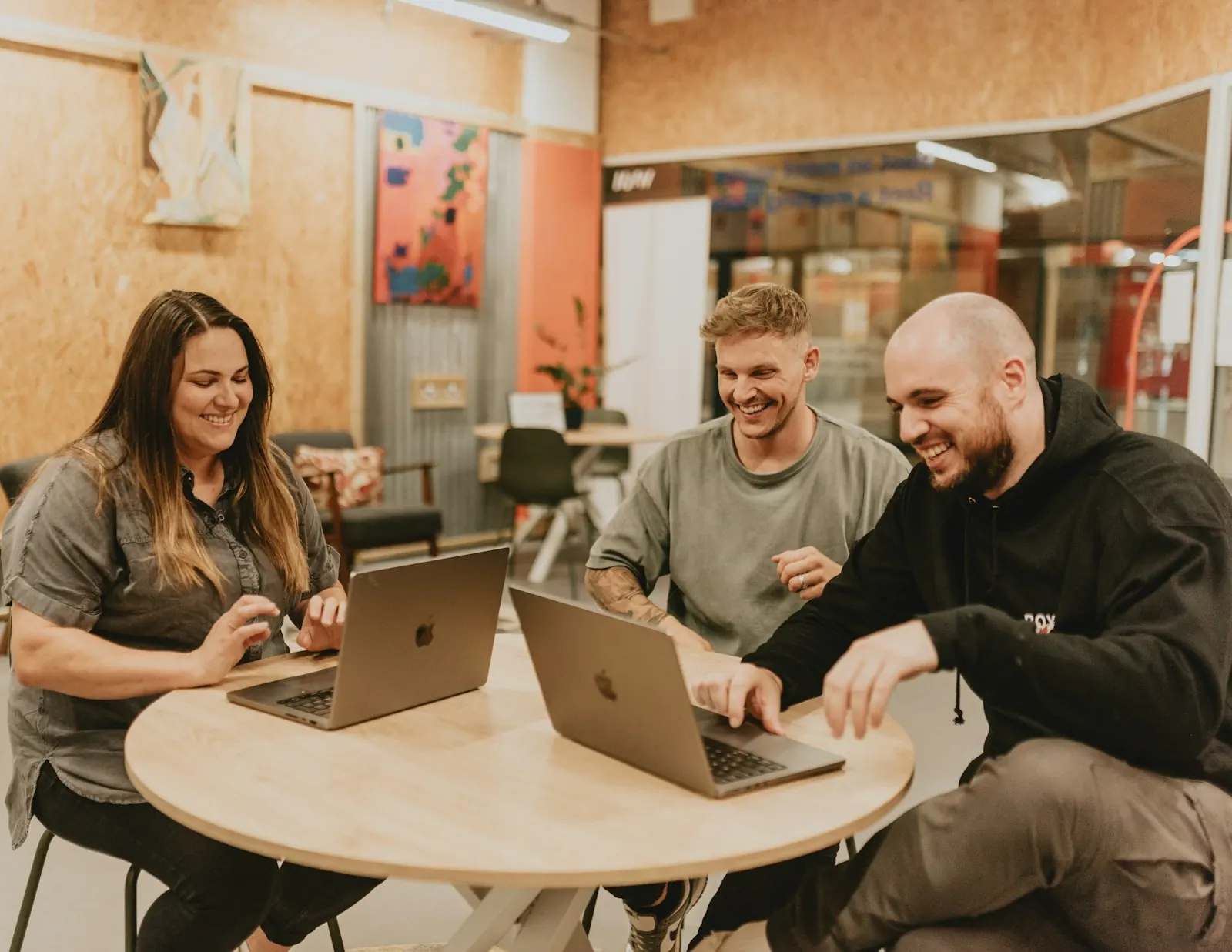 Equipo de trabajo sonriente revisando una aplicación en sus notebooks