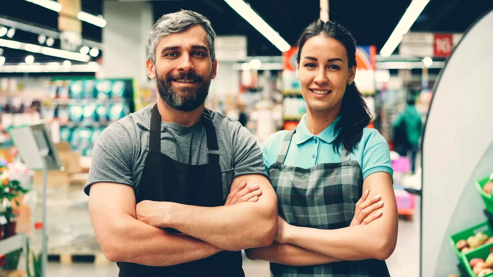 Dueños de un minimarket sonrientes en su local